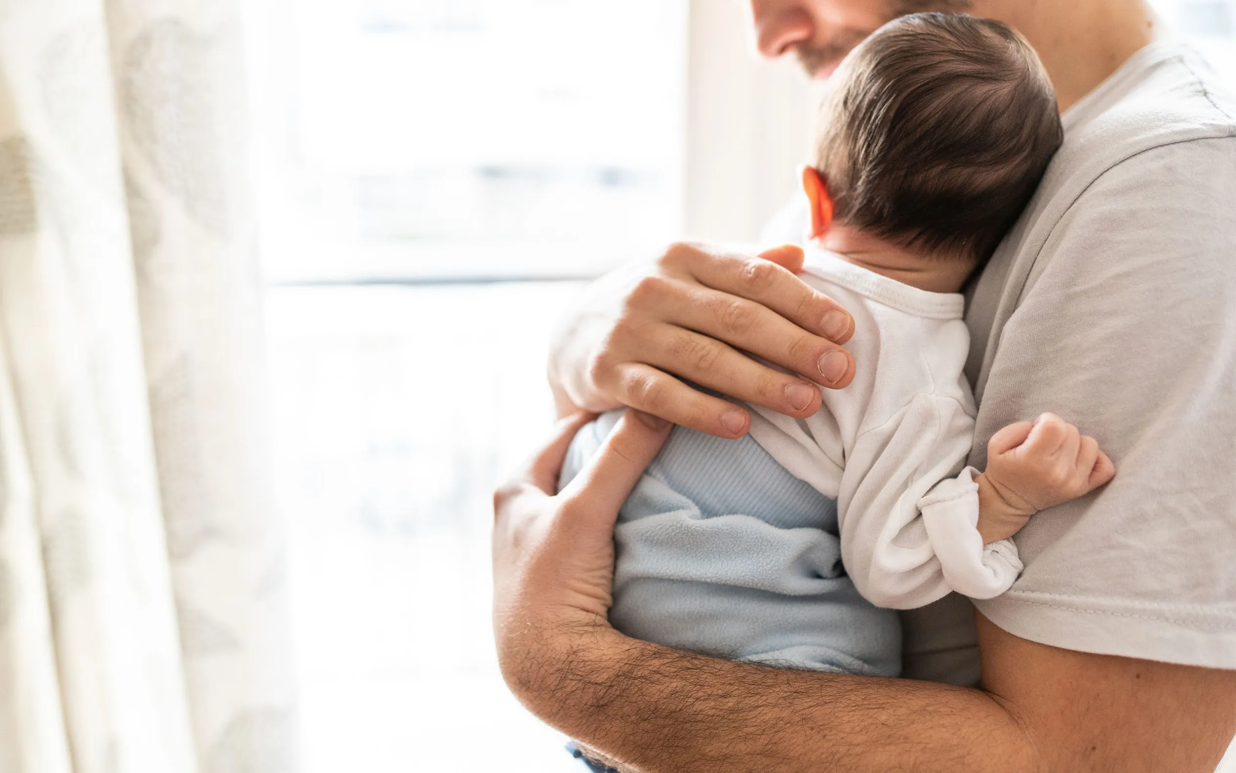 Vauva isän sylissä.