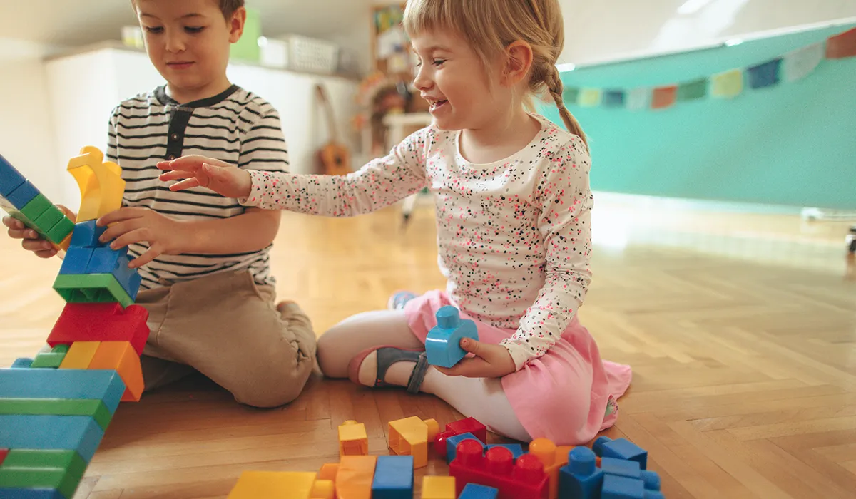 leluja lapsille: tyttö ja poika leikkivät palikoilla