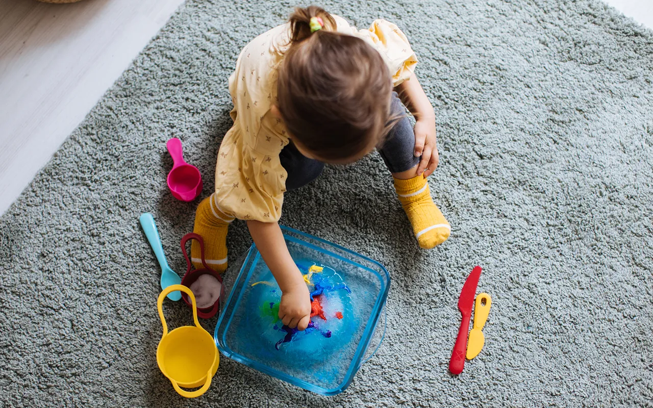 lumileikki sisällä: lapsi leikkii vedellä