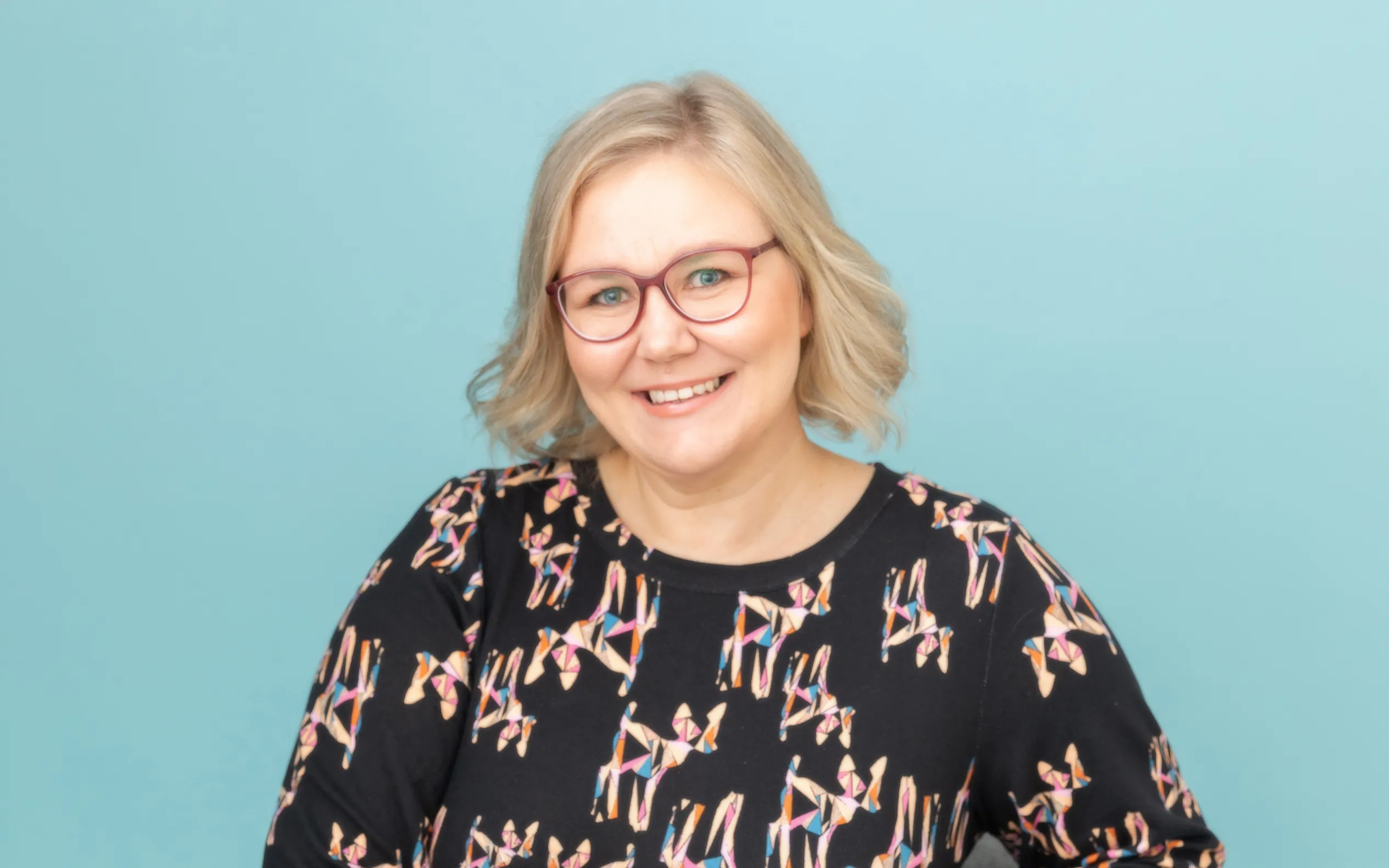 Kirjailija Krista Lomas hymyilee iloisesti.