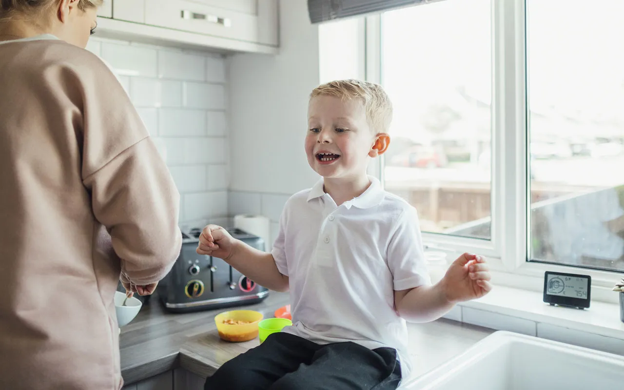 Lapsi puhuu äidilleen iloisena.